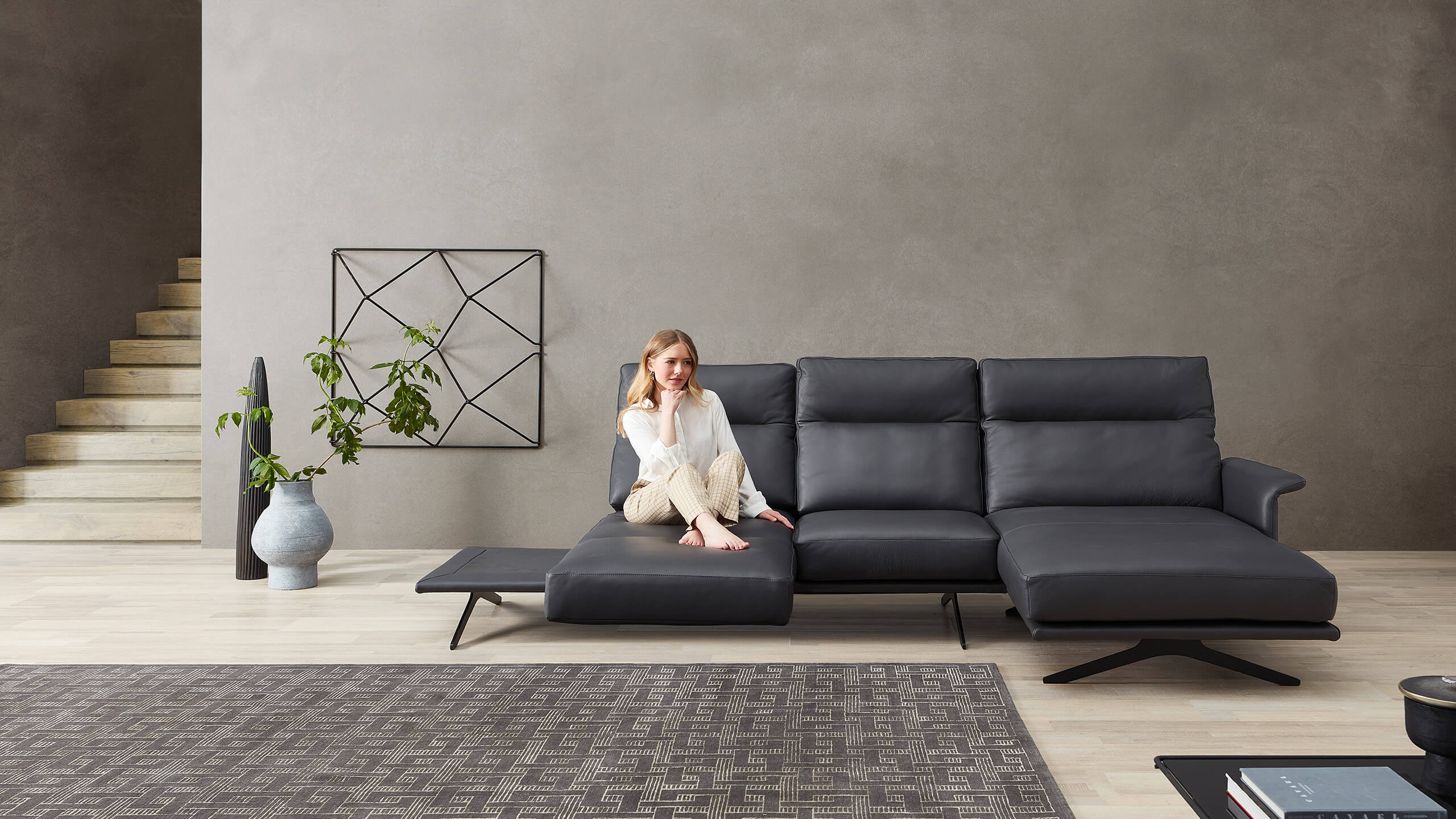 Cilia Ledersofa mit Longchair und Frau auf Dreh-Relaxsitz